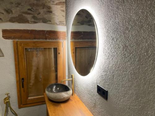 a mirror on a wall next to a wooden table at Roca negra Montseny in Fogars de Montclus