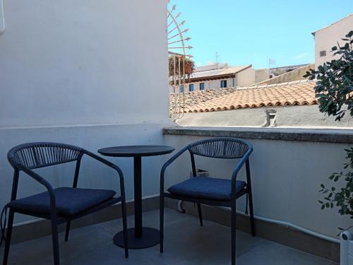 two chairs and a table on a balcony at Palazzo Salomone in Siracusa