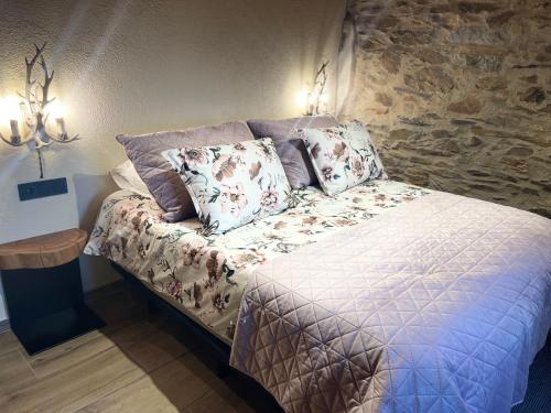 a bed in a room with a stone wall at Roca negra Montseny in Fogars de Montclus