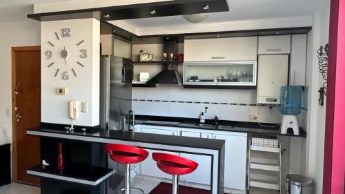 eine Küche mit zwei roten Stühlen an der Theke in der Unterkunft Departamento Libertad in Villa Carlos Paz