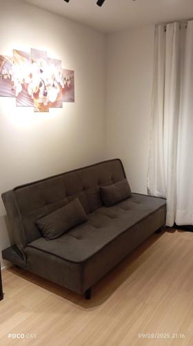 a couch sitting in a living room next to a window at Studio com vista espetacular! in Niterói