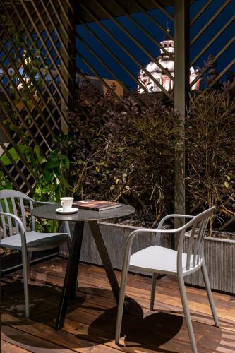 a table with two chairs and a coffee cup on it at Tá Hotel de diseño in Querétaro