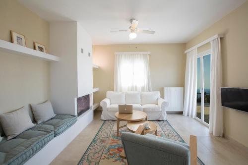 a living room with two couches and a table at Boo Premium Living Villas in Tsoukaladhes