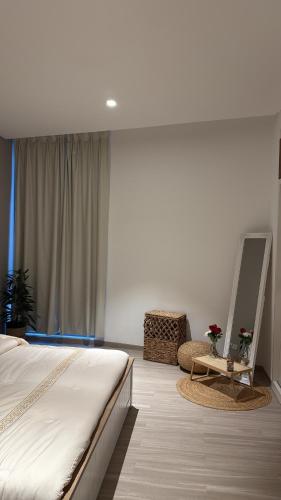a bedroom with a bed and a mirror and a chair at One way flat in Muscat