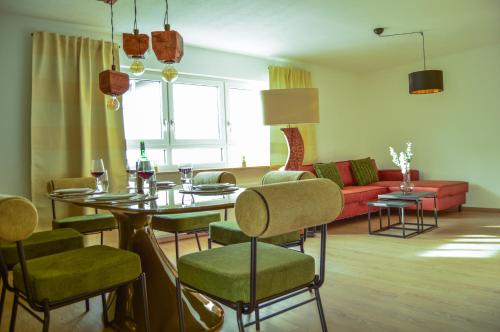 un salon avec une table, des chaises et un canapé dans l'établissement Wellness & Fun am Bodensee - mit Pool, Kino, Tischkicker und Terrasse, à Markdorf