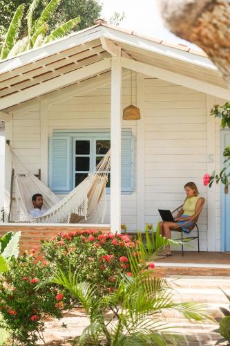 two people sitting in hammocks on the porch of a house at FlowHouse Jeri - Hotel & Coworking in Jericoacoara
