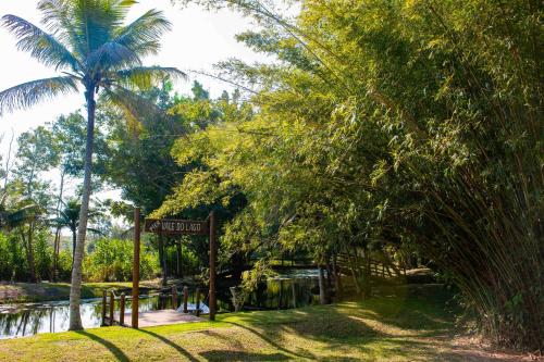 a sign for a park with a palm tree and a pond at Vale do Lago - Casa de Campo e Eventos in Vila Velha