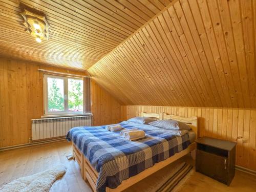 a bedroom with a bed in a wooden room at Садиба "Ековид" in Krivorovnya
