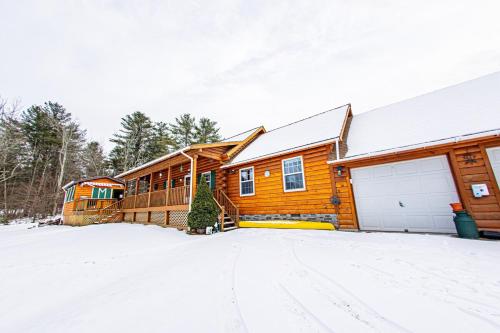 a log home in the snow with a driveway at Log Home w Mountain Views Near Windham & Hunter Ski Resorts in Maplecrest