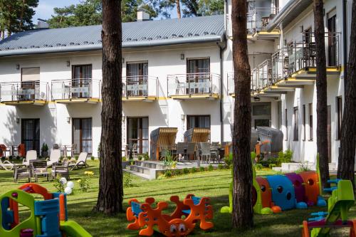 an apartment building with trees and playground equipment in the yard at Solaris in Pobierowo