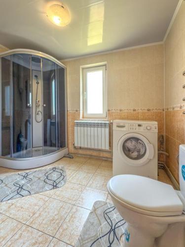 a bathroom with a toilet and a washing machine at Садиба "Ековид" in Krivorovnya