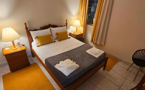 a bedroom with a large bed with yellow pillows at Hotel Barbacena in Barbacena