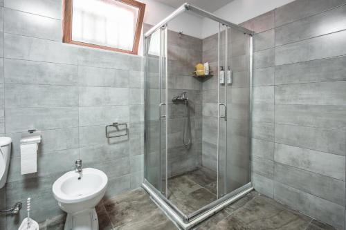 a bathroom with a shower and a toilet at Keshtjella Xhabeqos in Tirana