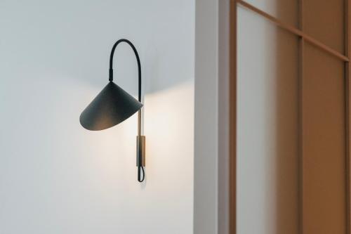 a black lamp hanging on a wall next to a door at Artifact Apart Hotel in Tbilisi City