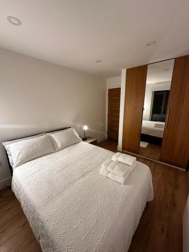 a bedroom with a white bed and a mirror at Room Imperial in London