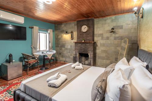 a large bed in a room with a fireplace at Keshtjella Xhabeqos in Tirana