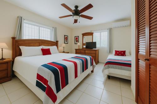 une chambre avec deux lits et un ventilateur de plafond dans l'établissement Spacious 3BR Home w Pool Near Palm Beach, à Saliña Cerca