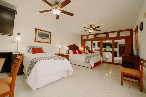 a hotel room with two beds and a television at Pool Home Near Palm Beach Plaza – Sleeps 13 in Saliña Cerca