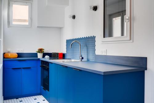 a kitchen with blue cabinets and a sink at Madeleine Bleue - Heart of Toulouse - Air conditioning, WiFi in Toulouse