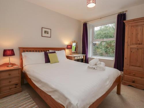 ein Schlafzimmer mit großem Bett und Fenster in der Unterkunft Cloud Cottage in Ambleside