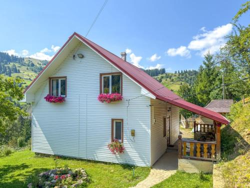 a white house with a red roof with flowers on it at Садиба "Ековид" in Krivorovnya
