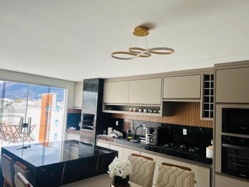 a kitchen with a black counter top at Penthouse with a privileged view in Governador Valadares