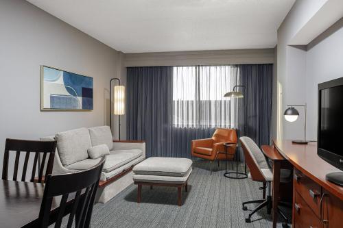 a living room with a couch and a dining room at Courtyard Long Island MacArthur Airport in Ronkonkoma