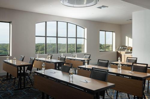 a conference room with tables and chairs and windows at Courtyard Long Island MacArthur Airport in Ronkonkoma