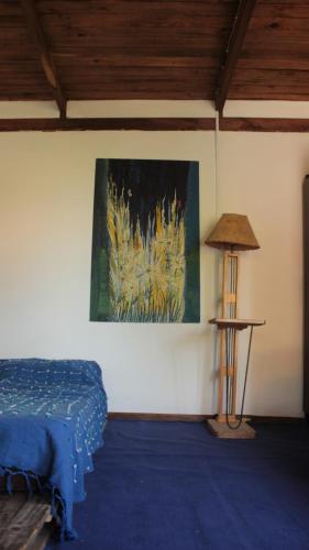a bedroom with a bed and a painting on the wall at Mama Killa Neptunia Eco hostel in Salinas 