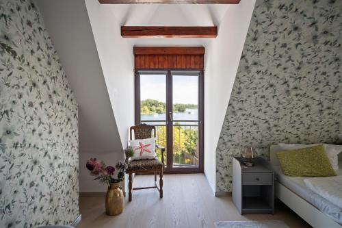 a room with a bed and a chair and a window at Ferienhaus Wasserblick in der Inselstadt Malchow in Malchow
