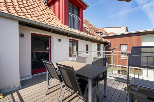 a wooden deck with a table and chairs on a balcony at Ferienhaus Wasserblick in der Inselstadt Malchow in Malchow