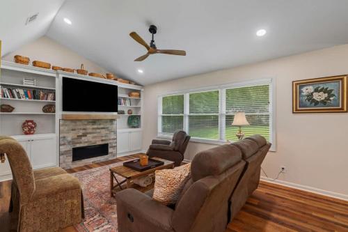 a living room with a couch and a tv at Magnolia Retreat in Hattiesburg