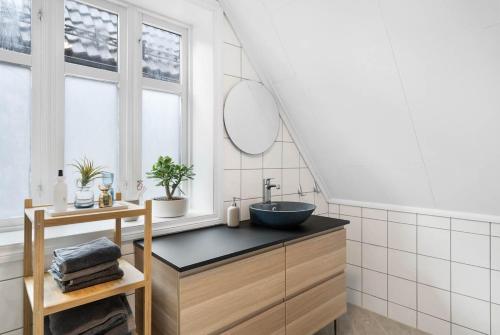 ein Badezimmer mit Waschbecken und Spiegel in der Unterkunft Historic Bergen house in the middle of the city center in Bergen