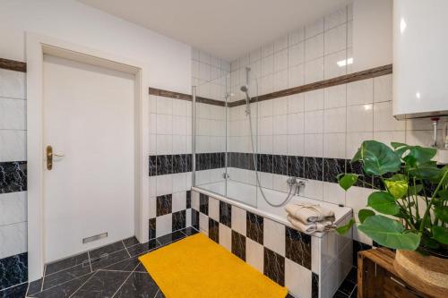 a bathroom with a shower and a yellow rug at Die große Hoamat in Gröbming