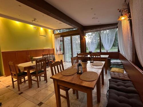 ein Esszimmer mit Holztischen und Stühlen in der Unterkunft Szepty Lasu in Szklarska Poręba