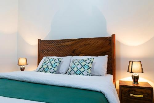 a bedroom with a bed with two lamps on tables at Comfortable and sophisticated Apartment in Kampala