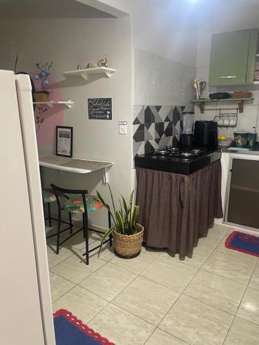 a kitchen with a counter and a table in it at Kitnet Adorável na sedede Aracruz ES 1KM do centro individual wifi cozinha equipada in Aracruz