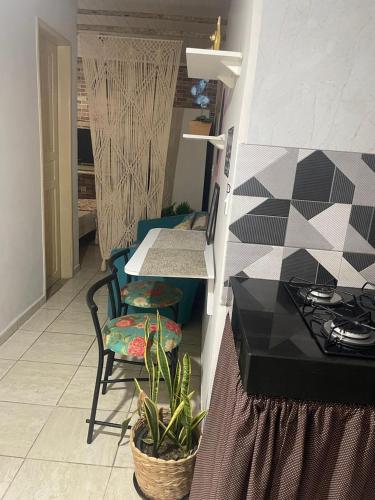 a kitchen with a table and chairs and a table at Kitnet Adorável na sedede Aracruz ES 1KM do centro individual wifi cozinha equipada in Aracruz