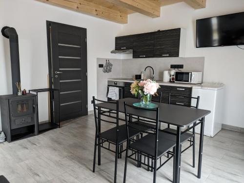 a kitchen with a black table and chairs and a kitchen with a stove at Apartmány U Lazara in Kutná Hora