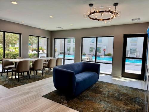 a living room with a blue chair and a table at La Quinta Inn by Wyndham Orlando International Drive North in Orlando