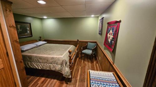 a bedroom with a bed and a chair in it at Mountain View 2BR Log Cabin Apt wPrivate BBQ Deck in Sylva
