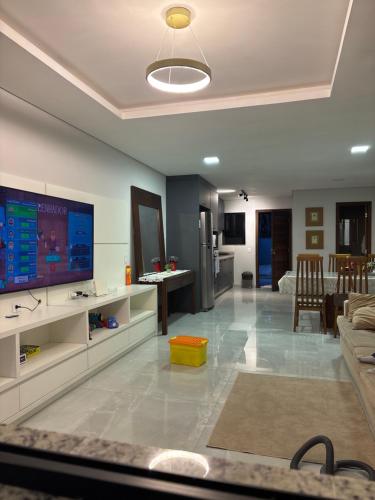 a living room with a flat screen tv and a couch at Casa Joinville in Joinville