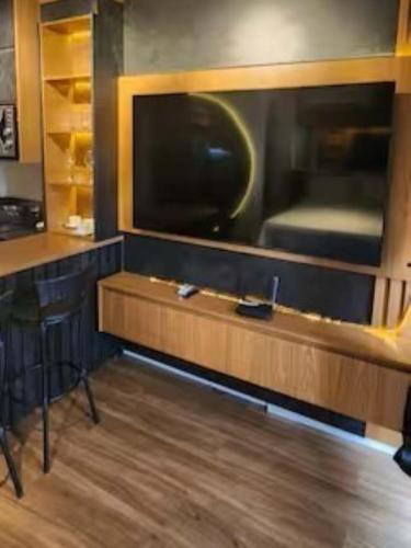 a room with a bar with a large television at Flat Exclusivo Studio Cuiabá 1604 in Cuiabá
