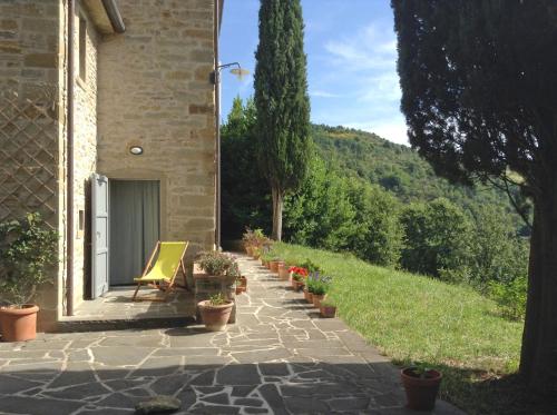 a patio with a chair and potted plants in front of a building at La Doccia in Anghiari