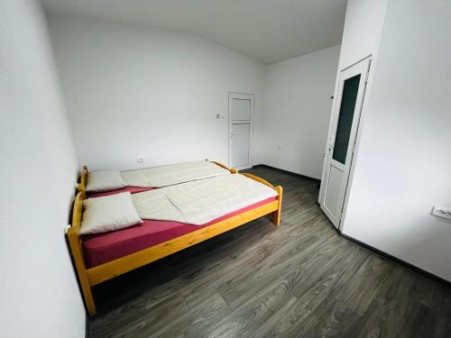 Un dormitorio con una cama en una habitación blanca. en Centrum, en Odorheiu Secuiesc