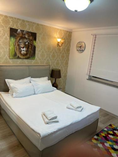 a bedroom with a bed with a lion painting on the wall at Pensiunea Bianca in Botoşani