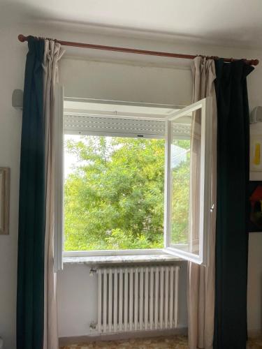 a window in a room with curtains and a radiator at Ars in Villa in Livorno