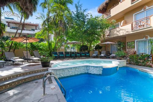 a swimming pool in front of a building at Hotel Riviera Del Sol in Playa del Carmen