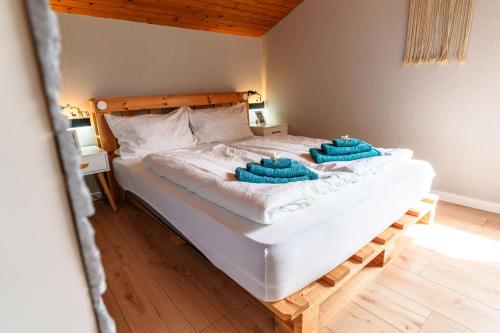 ein großes weißes Bett mit zwei blauen Handtüchern darauf in der Unterkunft Entspannung mitten im Schwarzwald mit Infrarotsauna und Massagesessel in Schönwald