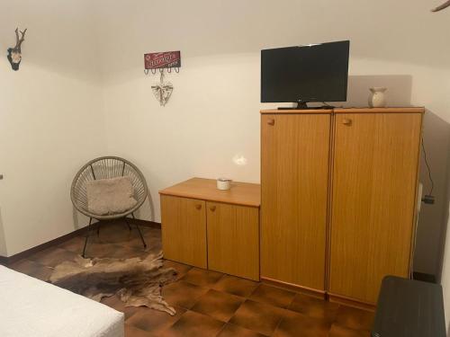 a bedroom with a tv on top of a wooden cabinet at BassottHouse in Albera Ligure